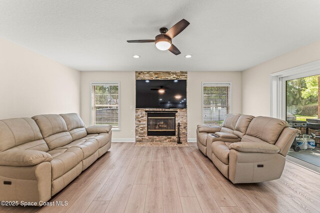 2225 Royal Oaks Dr, Rockledge, FL 32955 - living area with light wood-style flooring, a fireplace, healthy amount of natural light, ceiling fan, and recessed lighting