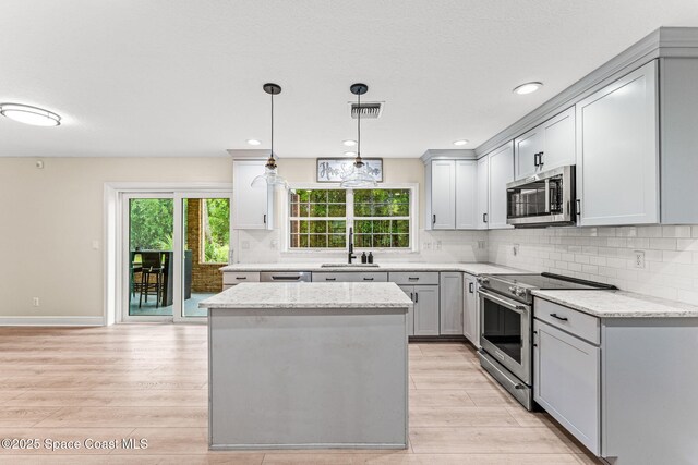 2225 Royal Oaks Dr, Rockledge, FL 32955 - kitchen with stainless steel appliances, light wood-style flooring, a sink, gray cabinetry, and recessed lighting
