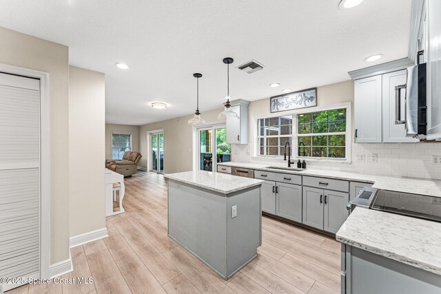 2225 Royal Oaks Dr, Rockledge, FL 32955 - kitchen with a sink, stainless steel appliances, tasteful backsplash, a kitchen island, and gray cabinets