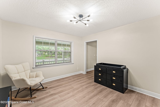 2225 Royal Oaks Dr, Rockledge, FL 32955 - living area with a chandelier, light wood-style floors, baseboards, and a textured ceiling