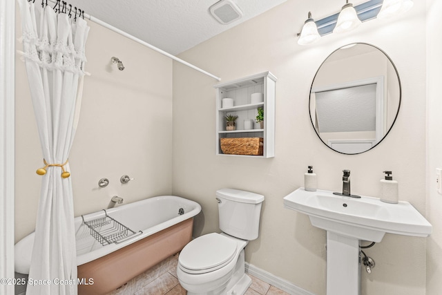 2225 Royal Oaks Dr, Rockledge, FL 32955 - bathroom featuring toilet, a tub to relax in, baseboards, tile patterned floors, and a textured ceiling