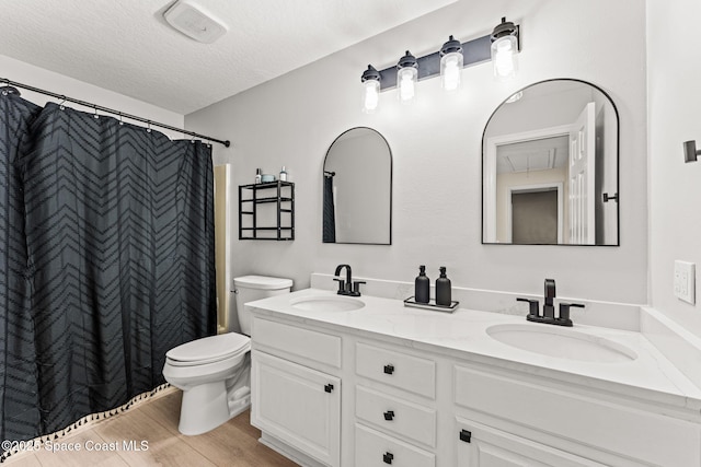 2225 Royal Oaks Dr, Rockledge, FL 32955 - full bathroom with toilet, double vanity, a textured ceiling, and wood finished floors