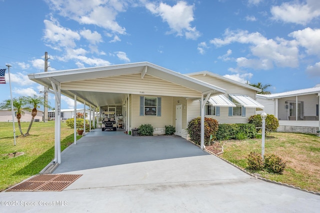 7685 Fox Hunter Cir, Micco, FL 32976 - manufactured / mobile home with driveway, a front lawn, and a carport
