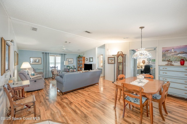 7685 Fox Hunter Cir, Micco, FL 32976 - dining area with light wood finished floors, a ceiling fan, a chandelier, crown molding, and vaulted ceiling
