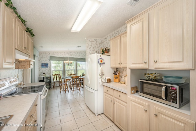 7685 Fox Hunter Cir, Micco, FL 32976 - kitchen with wallpapered walls, white appliances, under cabinet range hood, light tile patterned flooring, and light countertops