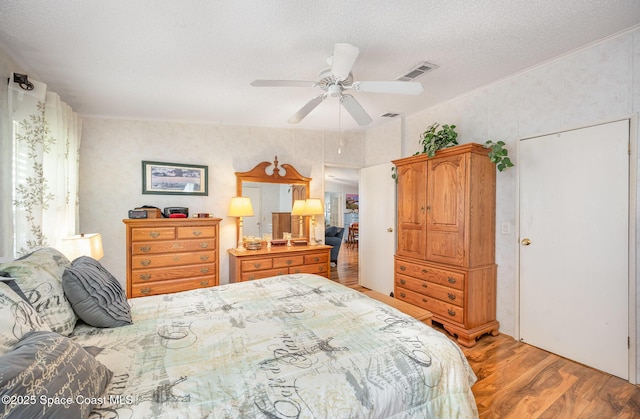 7685 Fox Hunter Cir, Micco, FL 32976 - bedroom featuring light wood-style floors, a textured ceiling, and a ceiling fan