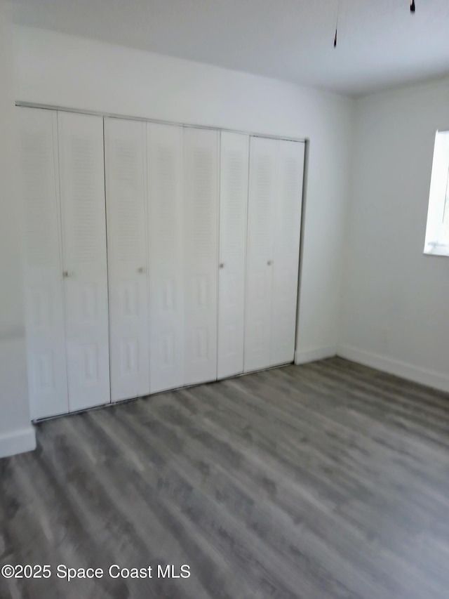 1641 Sunny Brook Ln NE Unit C110, Palm Bay, FL 32905 - unfurnished bedroom with wood finished floors, a closet, and baseboards