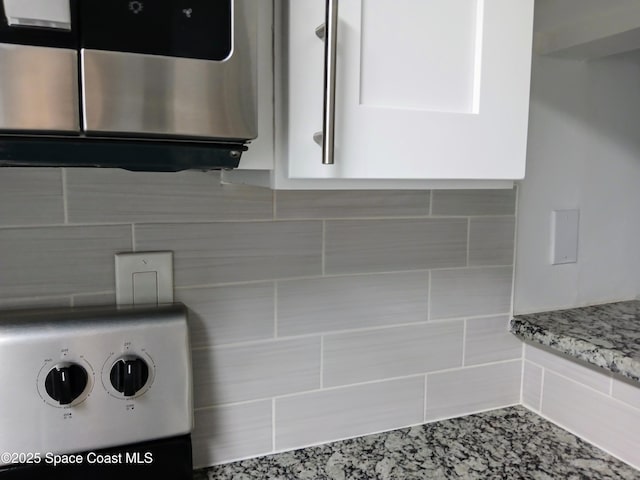 1641 Sunny Brook Ln NE Unit C110, Palm Bay, FL 32905 - kitchen view of tasteful backsplash, light stone counters, and stainless steel microwave