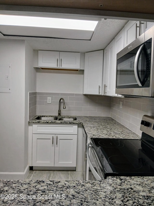 1641 Sunny Brook Ln NE Unit C110, Palm Bay, FL 32905 - kitchen featuring appliances with stainless steel finishes, a sink, light stone counters, and tasteful backsplash