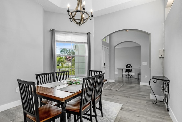 382 Eldron Blvd NE, Palm Bay, FL 32907 - dining area with a chandelier, arched walkways, baseboards, and light wood-style floors