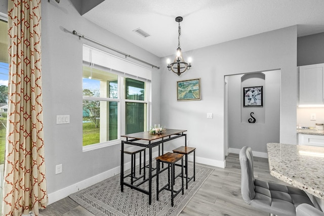 382 Eldron Blvd NE, Palm Bay, FL 32907 - dining area featuring a chandelier, light wood-style flooring, and baseboards