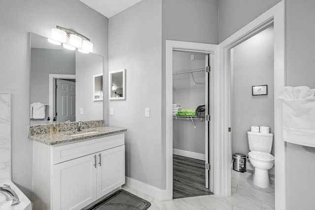 382 Eldron Blvd NE, Palm Bay, FL 32907 - bathroom featuring marble finish floors, vanity, a spacious closet, and toilet
