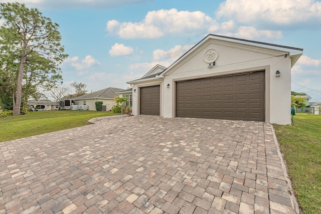 382 Eldron Blvd NE, Palm Bay, FL 32907 - ranch-style house with stucco siding, a front lawn, decorative driveway, and a garage