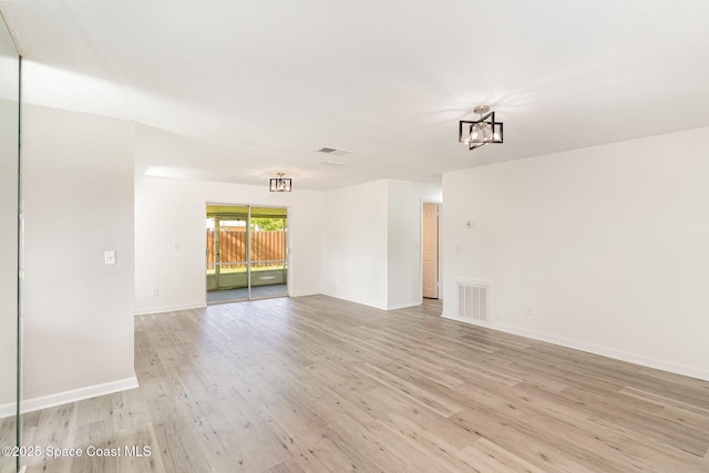 2885 Fountainhead Blvd, Melbourne, FL 32935 - empty room with light wood-style flooring and a chandelier