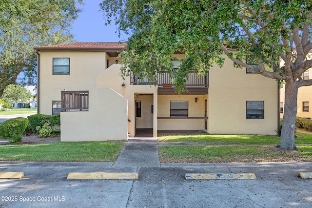 5630 N Banana River Blvd Unit 1, Cocoa Beach, FL 32931 - view of front facade with a balcony, stucco siding, and uncovered parking
