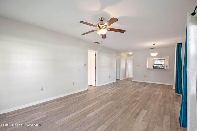 5630 N Banana River Blvd Unit 1, Cocoa Beach, FL 32931 - unfurnished living room featuring ceiling fan, light wood-style floors, and baseboards