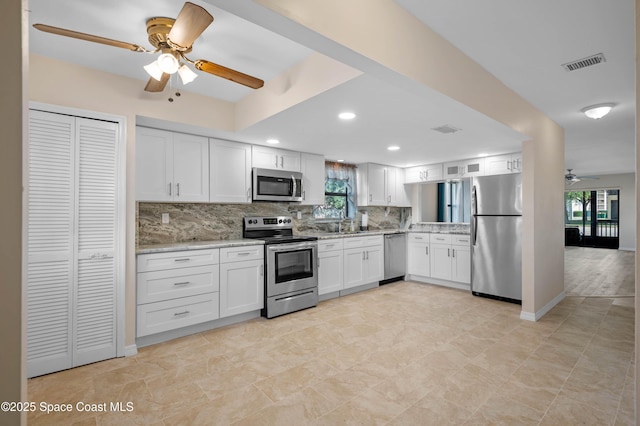 5630 N Banana River Blvd Unit 1, Cocoa Beach, FL 32931 - kitchen featuring stainless steel appliances, a ceiling fan, tasteful backsplash, a sink, and white cabinets