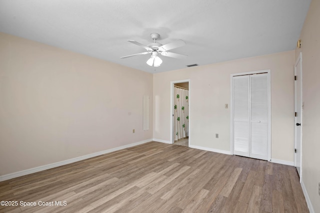 5630 N Banana River Blvd Unit 1, Cocoa Beach, FL 32931 - unfurnished bedroom featuring light wood-type flooring, a closet, baseboards, and ceiling fan