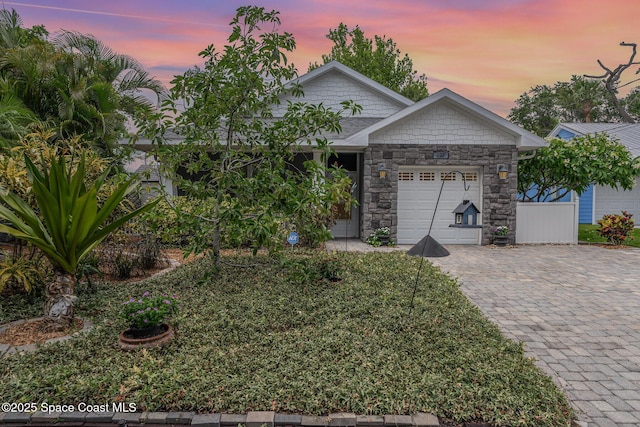 210 Sutton St, Rockledge, FL 32955 - view of front of house with a garage, stone siding, and decorative driveway