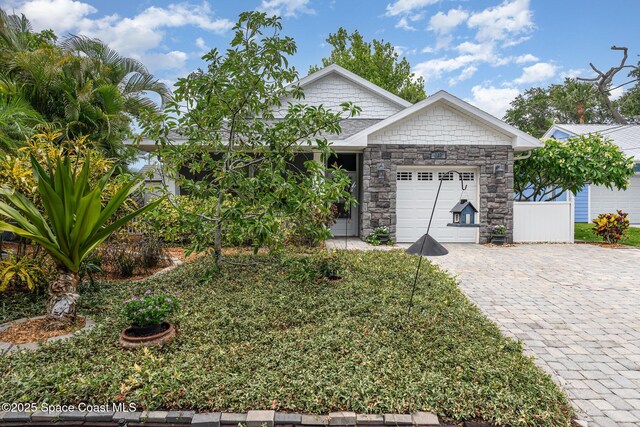 210 Sutton St, Rockledge, FL 32955 - view of front of property with a garage, decorative driveway, and stone siding