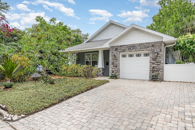 210 Sutton St, Rockledge, FL 32955 - view of front of house with an attached garage, stone siding, decorative driveway, and roof with shingles