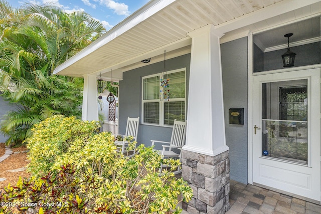 210 Sutton St, Rockledge, FL 32955 - view of exterior entry with covered porch, stucco siding, and stone siding