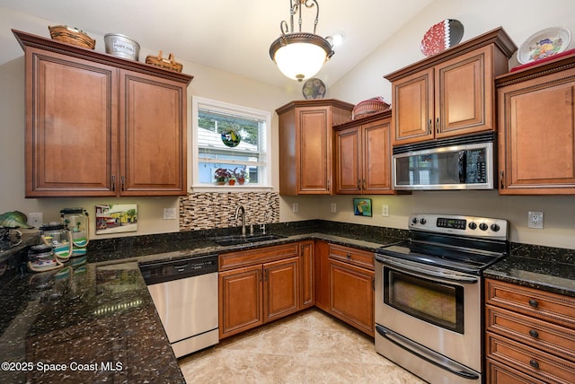210 Sutton St, Rockledge, FL 32955 - kitchen featuring stainless steel appliances, a sink, brown cabinetry, and dark stone countertops