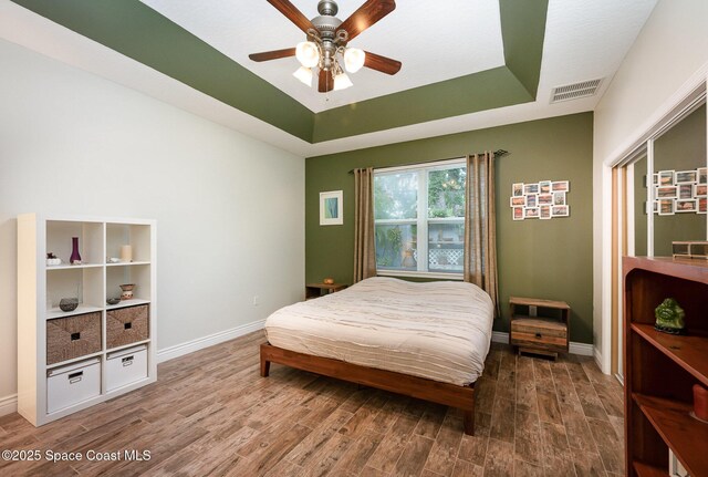 210 Sutton St, Rockledge, FL 32955 - bedroom with a raised ceiling, wood finished floors, baseboards, and ceiling fan