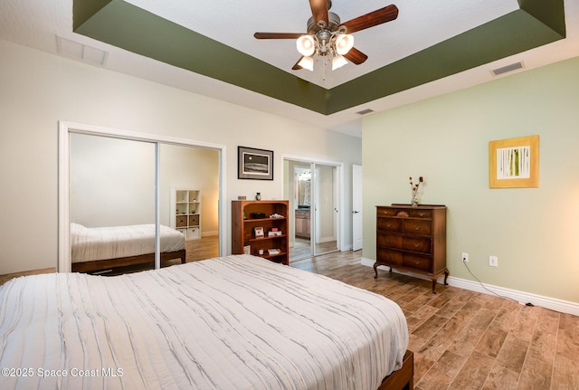 210 Sutton St, Rockledge, FL 32955 - bedroom featuring light wood-type flooring, baseboards, a raised ceiling, a closet, and a ceiling fan