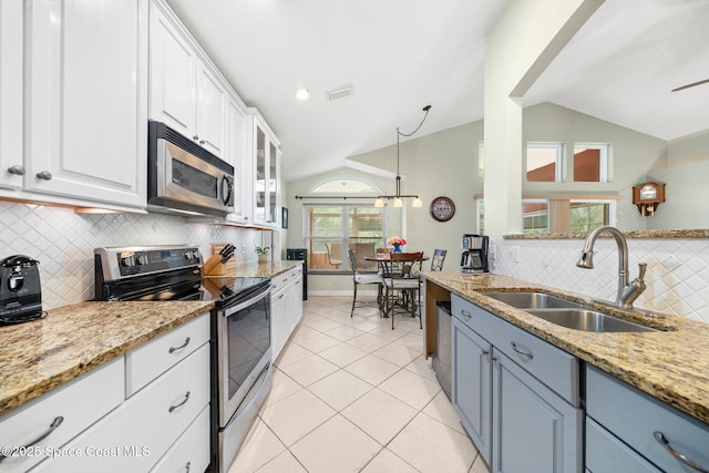 1398 Stuttgart Ave NW, Palm Bay, FL 32907 - kitchen featuring stainless steel appliances, a sink, vaulted ceiling, white cabinets, and decorative backsplash