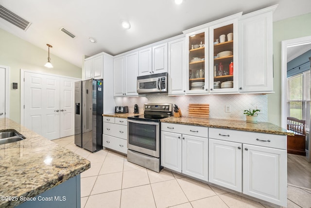 1398 Stuttgart Ave NW, Palm Bay, FL 32907 - kitchen featuring stainless steel appliances, white cabinetry, decorative backsplash, lofted ceiling, and glass insert cabinets
