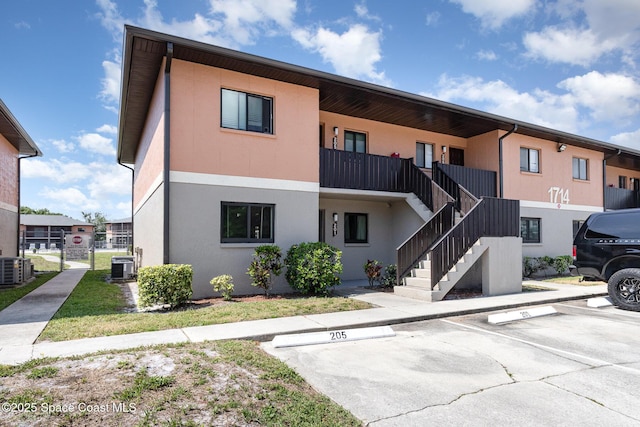 1714 University Ln Unit 201, Cocoa, FL 32922 - view of property with central AC, uncovered parking, and stairs