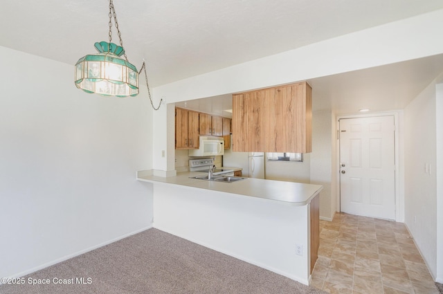 1714 University Ln Unit 201, Cocoa, FL 32922 - kitchen with white appliances, light countertops, a sink, a peninsula, and baseboards