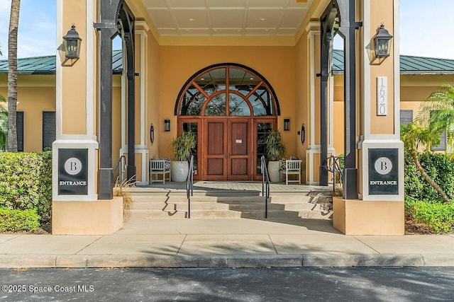 1629 Baseline Ln, Vero Beach, FL 32967 - view of exterior entry with a standing seam roof, stucco siding, metal roof, and a porch