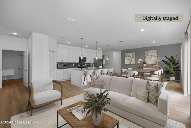 278 Gates St SW, Palm Bay, FL 32908 - living room featuring recessed lighting, light wood-type flooring, and baseboards