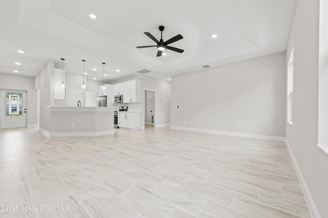 8286 100th Ave, Vero Beach, FL 32967 - unfurnished living room featuring a raised ceiling, ceiling fan, recessed lighting, and baseboards
