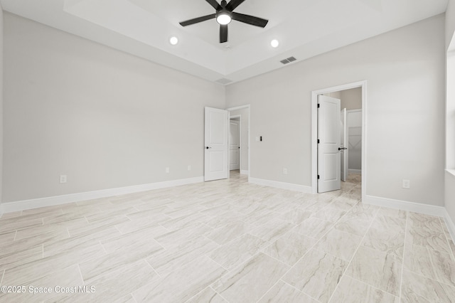 8286 100th Ave, Vero Beach, FL 32967 - unfurnished bedroom with a walk in closet, a raised ceiling, recessed lighting, ceiling fan, and baseboards
