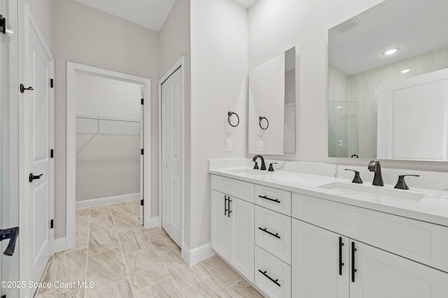 8286 100th Ave, Vero Beach, FL 32967 - bathroom featuring tiled shower, baseboards, double vanity, a spacious closet, and marble finish flooring