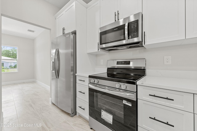 8286 100th Ave, Vero Beach, FL 32967 - kitchen with appliances with stainless steel finishes, light countertops, white cabinetry, and baseboards