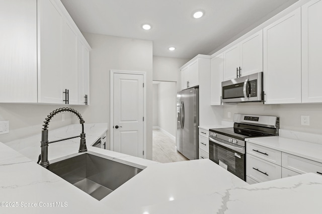 8286 100th Ave, Vero Beach, FL 32967 - kitchen with stainless steel appliances, a sink, white cabinets, and recessed lighting