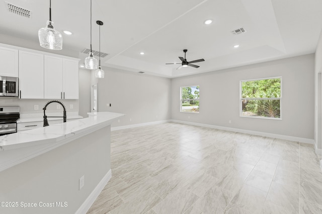 8286 100th Ave, Vero Beach, FL 32967 - unfurnished living room with a raised ceiling, a ceiling fan, recessed lighting, and baseboards