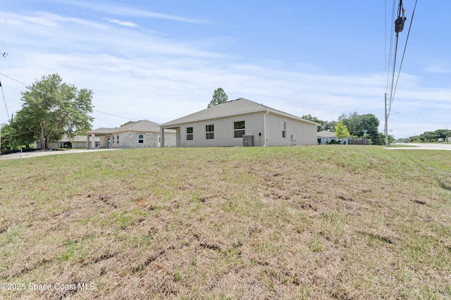 8286 100th Ave, Vero Beach, FL 32967 - view of front of home with cooling unit, stucco siding, and a front lawn