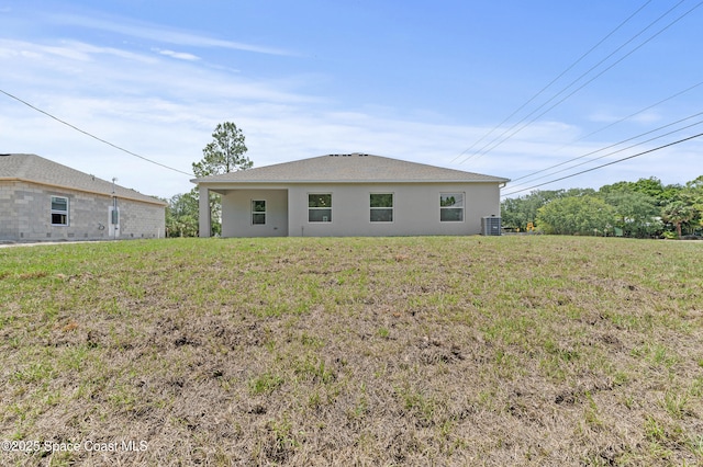8286 100th Ave, Vero Beach, FL 32967 - back of house featuring central AC unit, stucco siding, and a yard