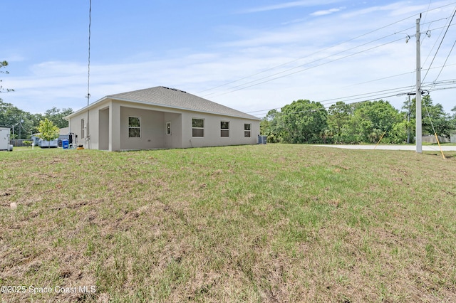 8286 100th Ave, Vero Beach, FL 32967 - rear view of property with stucco siding and a yard