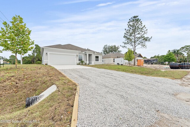 8286 100th Ave, Vero Beach, FL 32967 - ranch-style home featuring gravel driveway, an attached garage, a front lawn, and stucco siding