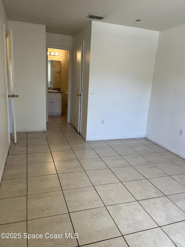 110 Summer Pl Unit 4, Merritt Island, FL 32953 - spare room with a textured ceiling, light tile patterned flooring, and baseboards