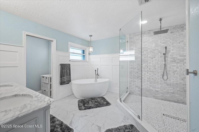 912 Hialeah St, Rockledge, FL 32955 - bathroom with a shower stall, a soaking tub, double vanity, marble finish floors, and a wainscoted wall
