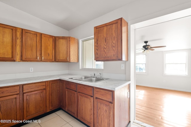 418 N Fiske Blvd, Cocoa, FL 32922 - kitchen with a sink, ceiling fan, brown cabinetry, light countertops, and vaulted ceiling