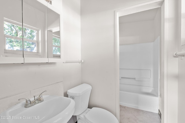 418 N Fiske Blvd, Cocoa, FL 32922 - bathroom featuring marble look tile flooring, toilet, a sink, and washtub / shower combination