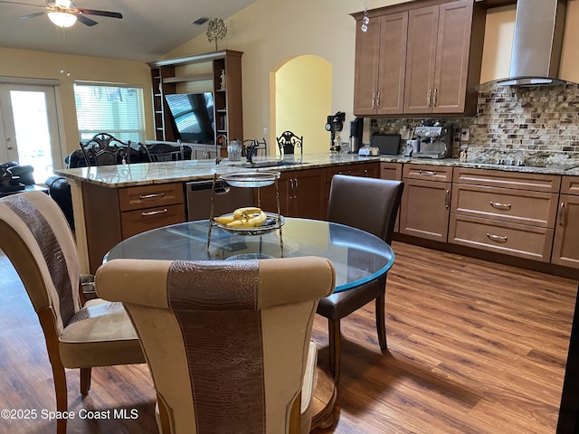 971 Sabal Grove Dr, Rockledge, FL 32955 - kitchen with wall chimney exhaust hood, a peninsula, vaulted ceiling, dark wood-type flooring, and ceiling fan